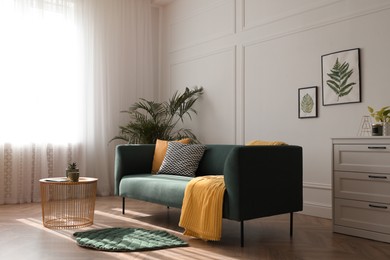 Stylish living room interior with comfortable green sofa