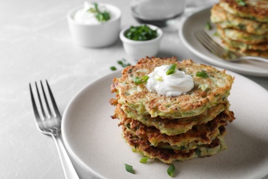 Delicious zucchini fritters served on light table, closeup