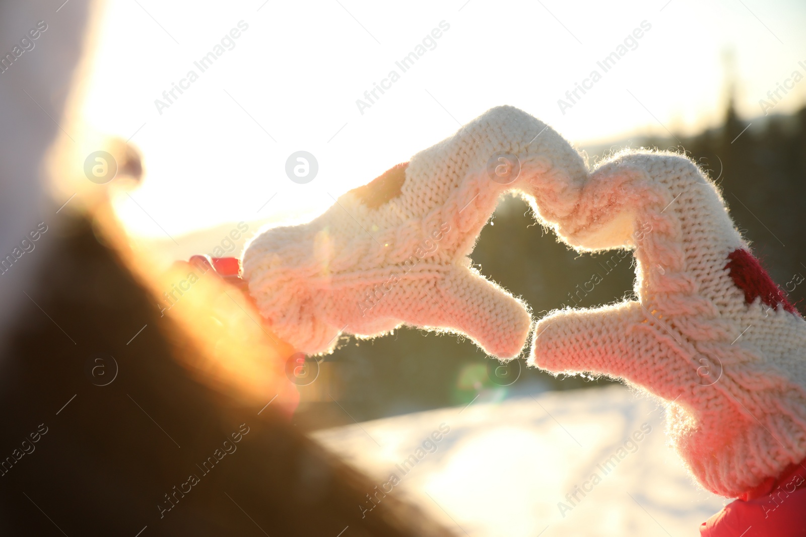 Photo of Woman making heart with hands outdoors, closeup. Winter vacation