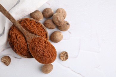 Photo of Nutmeg powder and seeds on white table, flat lay. Space for text