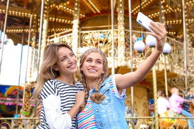 Photo of Attractive women taking selfie in amusement park