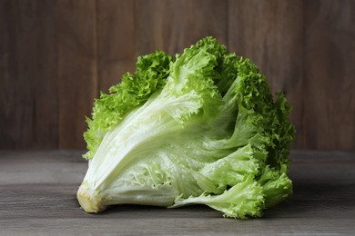 Photo of Fresh lettuce on wooden table. Salad greens