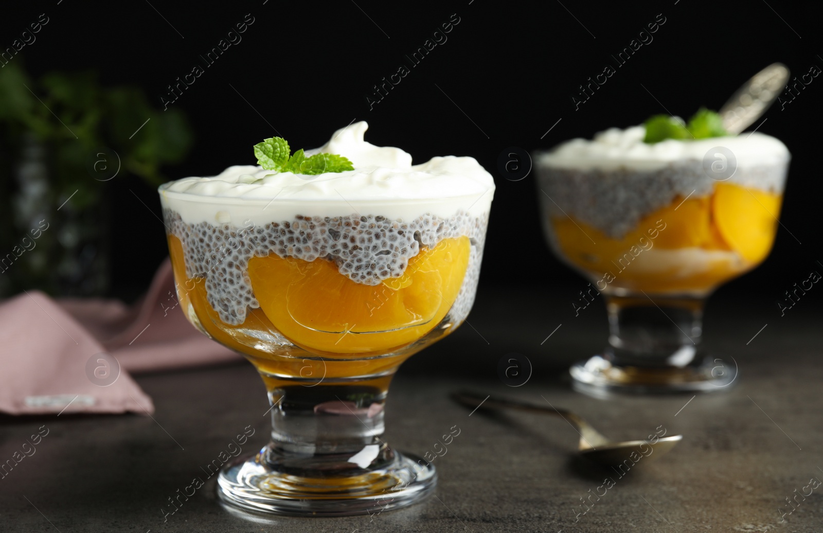 Photo of Tasty peach dessert with yogurt and chia seeds on grey table