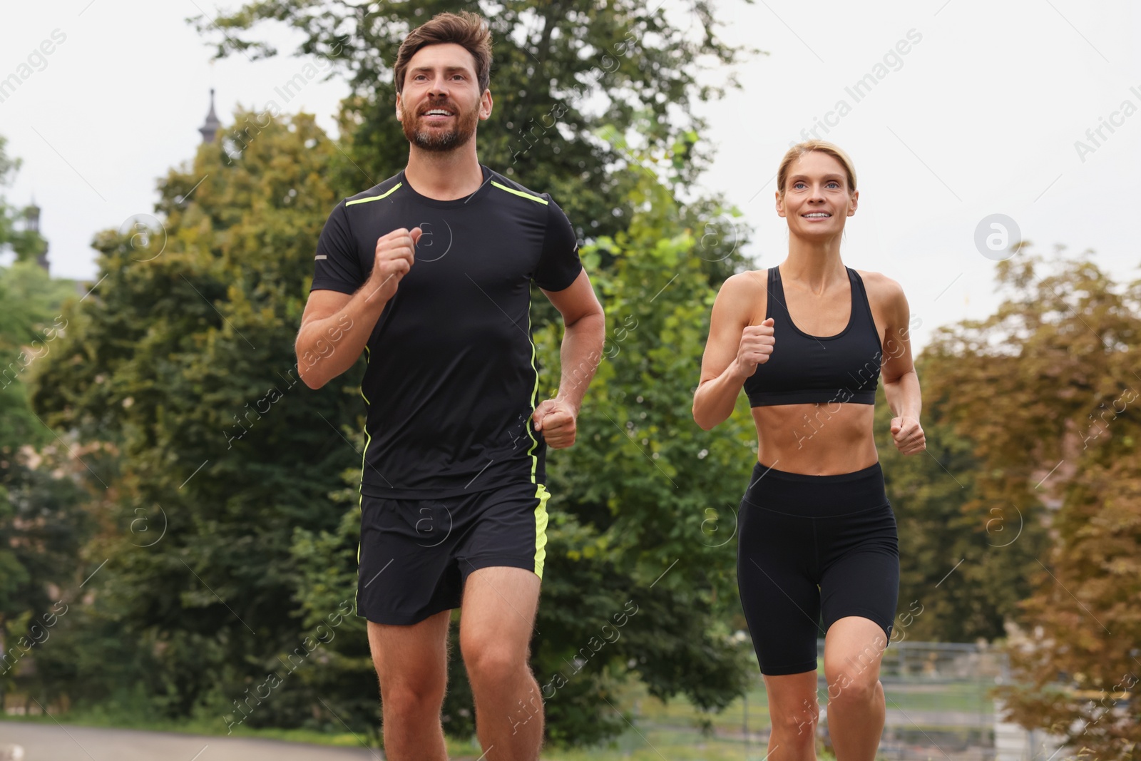 Photo of Healthy lifestyle. Happy sporty couple running outdoors