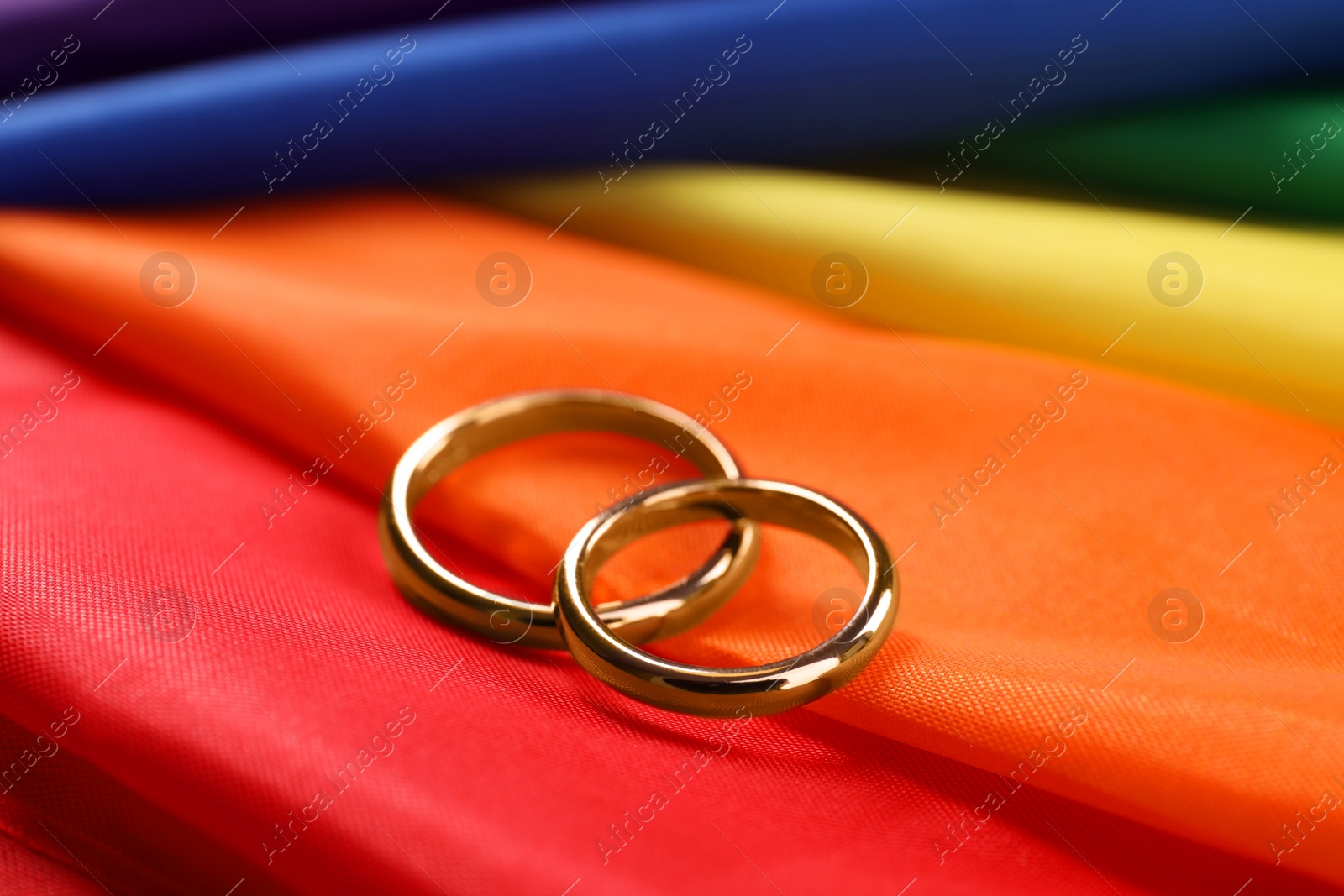 Photo of Wedding rings on rainbow LGBT flag, closeup