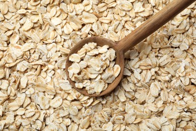 Photo of Closeup of wooden spoon on oatmeal, top view