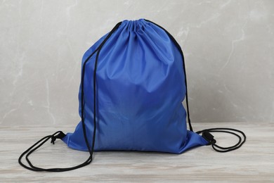 Photo of Blue drawstring bag on light wooden table