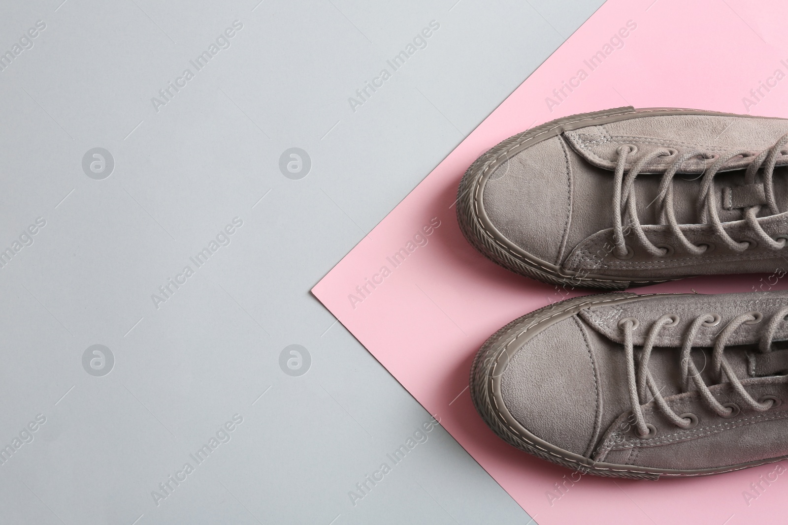 Photo of Stylish sneakers on color background, top view with space for text