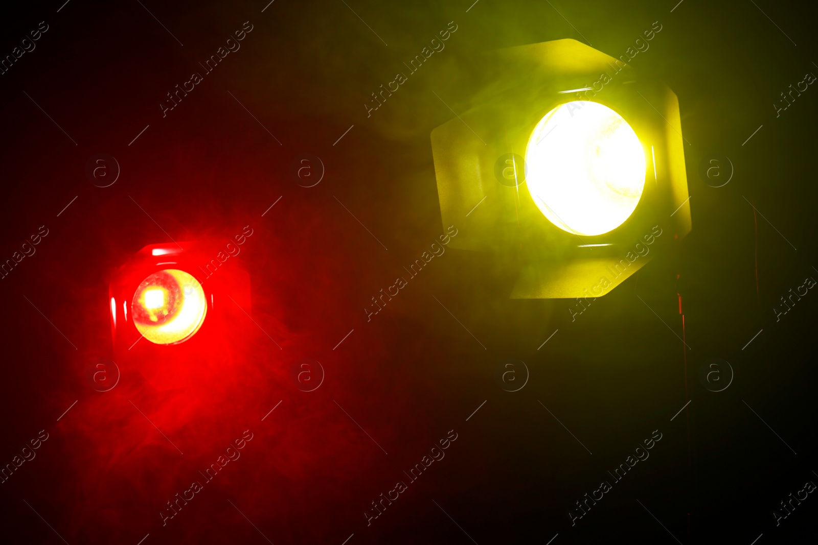 Photo of Bright colorful spotlights and smoke in darkness. Professional stage equipment