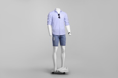 Photo of Male mannequin dressed in stylish shirt and denim shorts on grey background