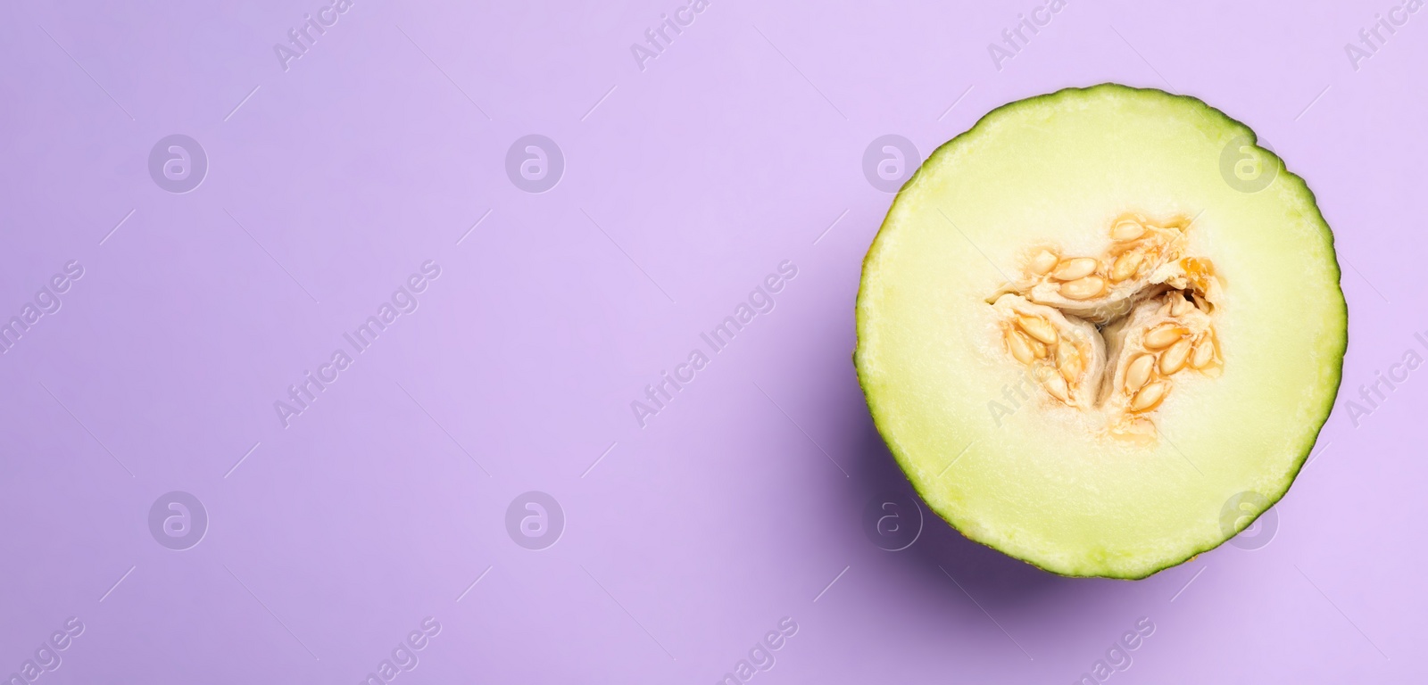 Photo of Half of ripe tasty melon on violet background, top view. Space for text