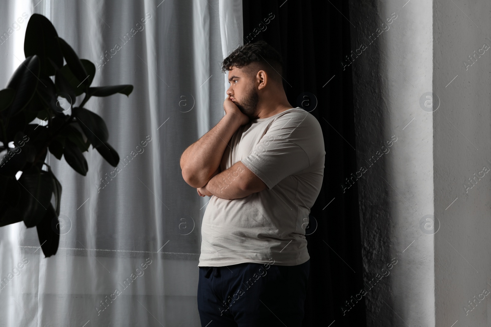 Photo of Overweight man suffering from depression at home