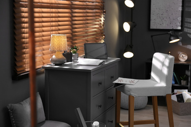 Photo of Stylish room interior with comfortable workplace near window