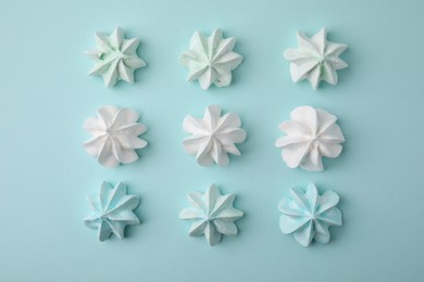 Photo of Delicious meringue cookies on light blue background, flat lay