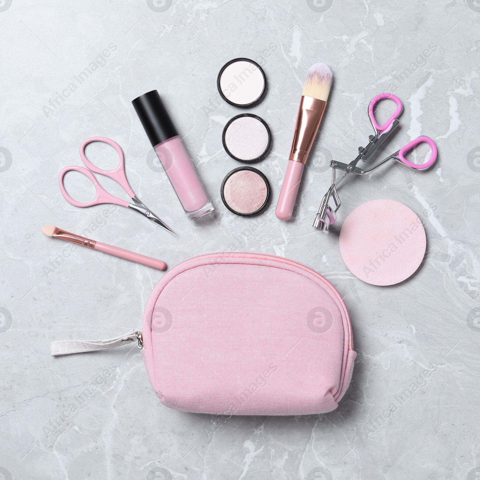 Photo of Cosmetic bag with makeup products and beauty accessories on light grey marble background