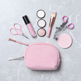 Photo of Cosmetic bag with makeup products and beauty accessories on light grey marble background