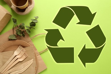 Image of Flat lay composition with eco friendly products and recycling symbol on light green background