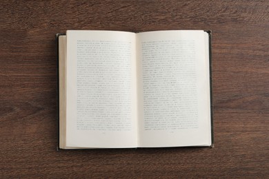 Open old hardcover book on wooden table, top view