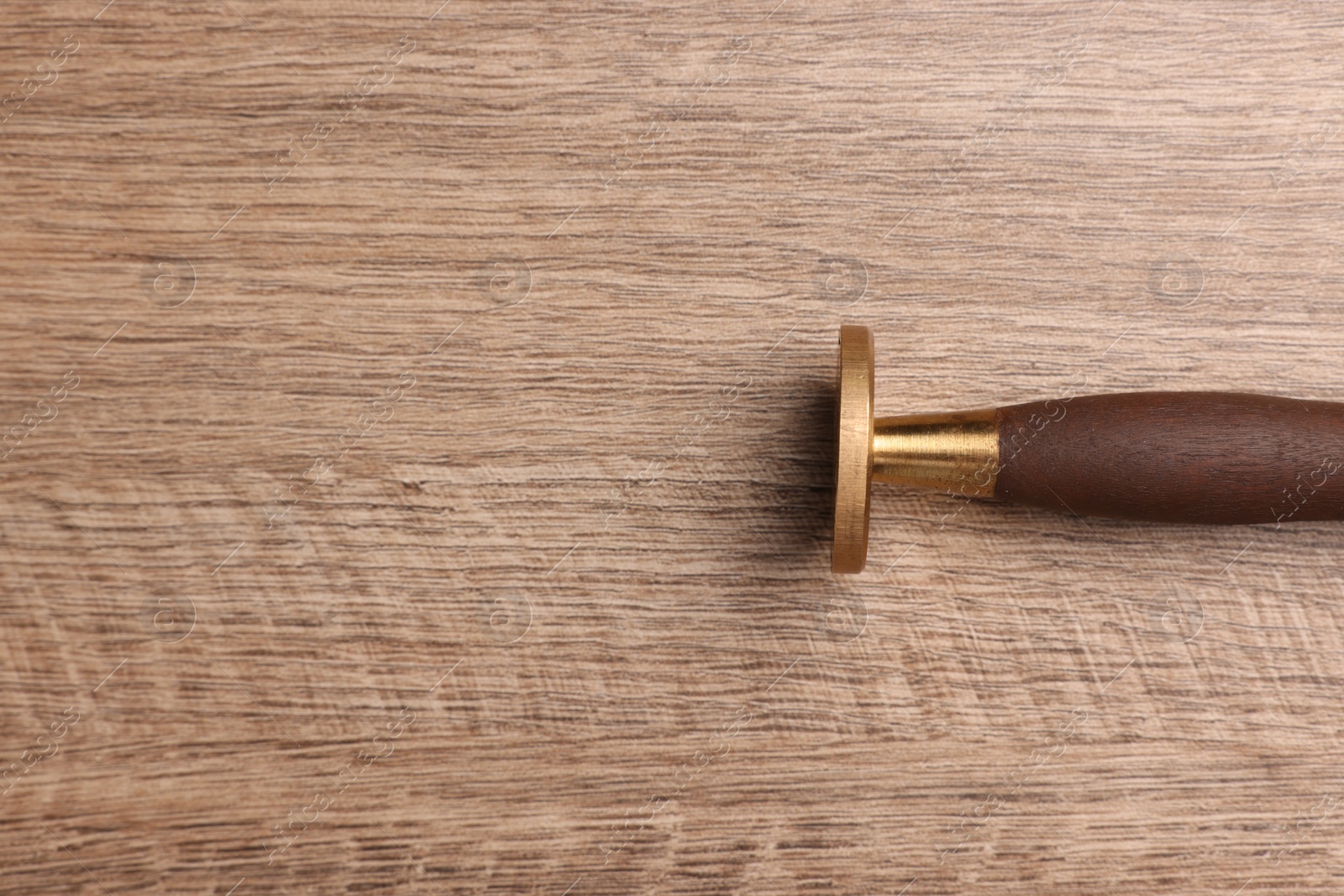 Photo of One stamp tool on wooden table, top view. Space for text