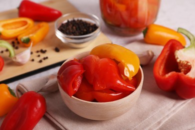 Photo of Tasty pickled peppers and fresh vegetables on table