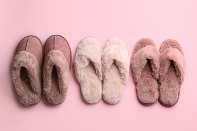 Different stylish soft slippers on pink background, flat lay