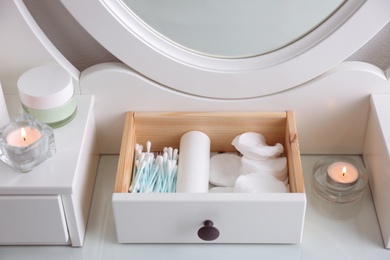 Photo of Drawer with cotton buds and pads in dressing table