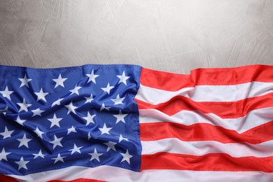 Photo of American flag on light grey background, top view. Space for text