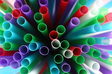 Heap of colorful plastic straws for drinks as background, closeup