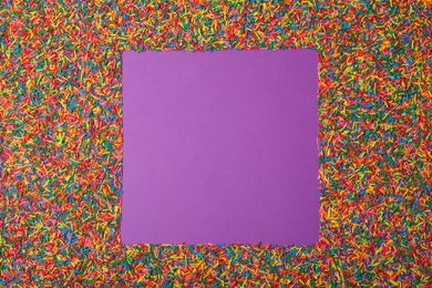 Photo of Frame of sprinkles on purple background, flat lay with space for text. Confectionery decor