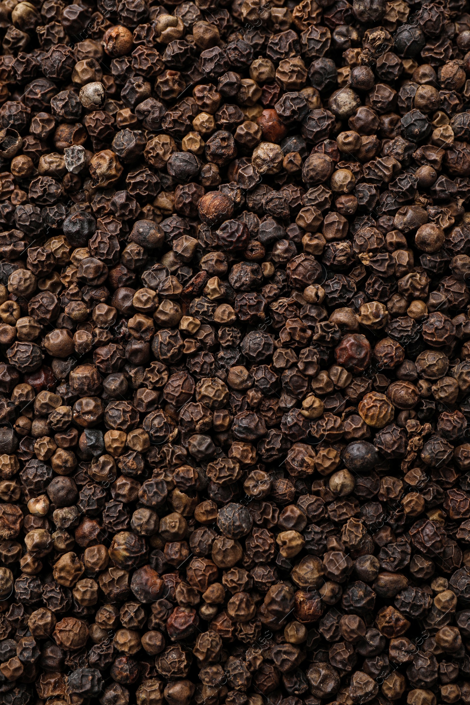 Photo of Aromatic black peppercorns as background, top view