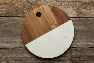 Photo of One new cutting board on old wooden table, top view