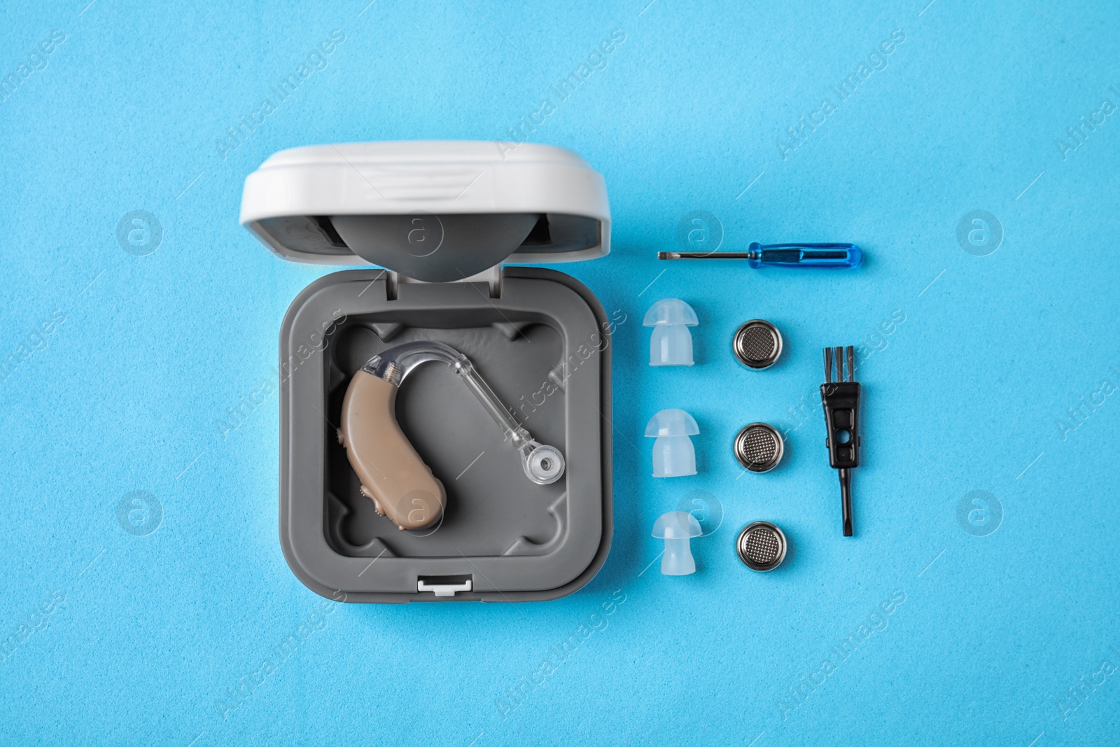 Photo of Flat lay composition with hearing aid and accessories on color background