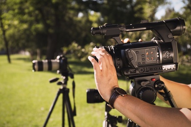 Professional video camera operator working outdoors, closeup