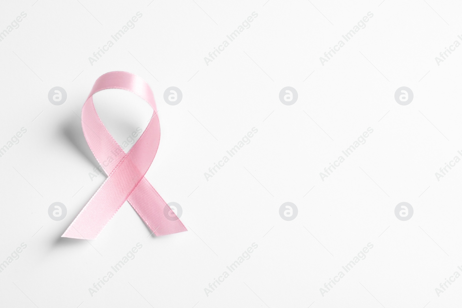 Photo of Pink ribbon on white background, top view. Cancer awareness