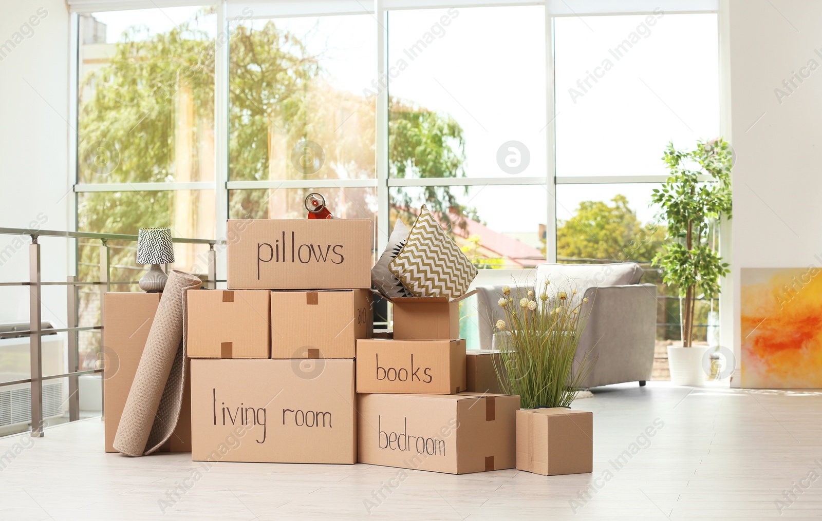 Photo of Cardboard boxes and household stuff indoors. Moving day