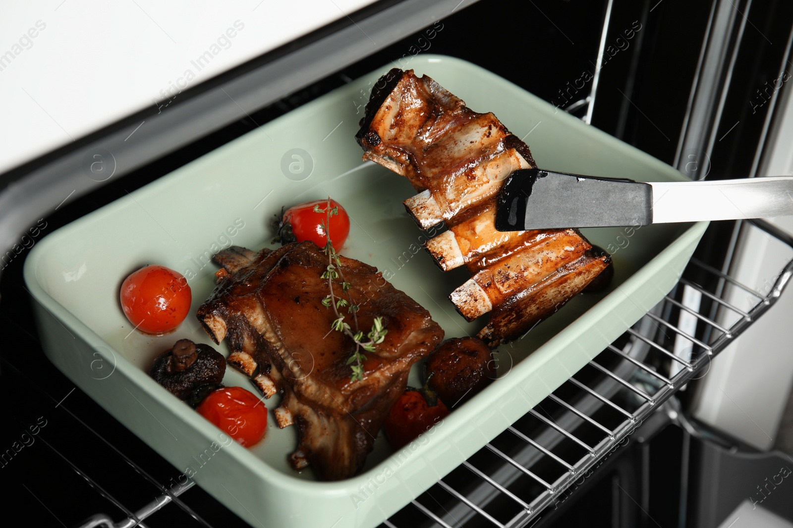 Photo of Delicious roasted ribs in oven. Yummy meat