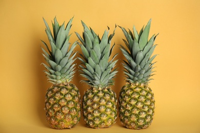 Photo of Fresh ripe juicy pineapples on orange background