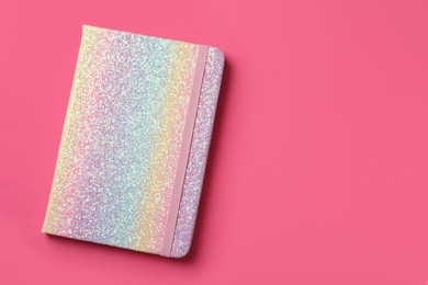 Photo of New stylish planner with hard cover on pink background, top view. Space for text