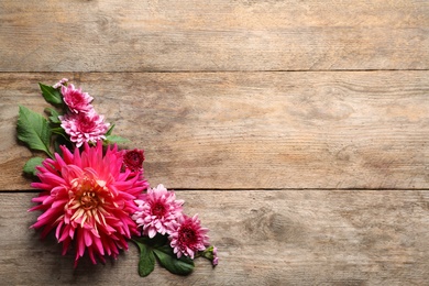 Photo of Flat lay composition with beautiful dahlia flowers and space for text on wooden background