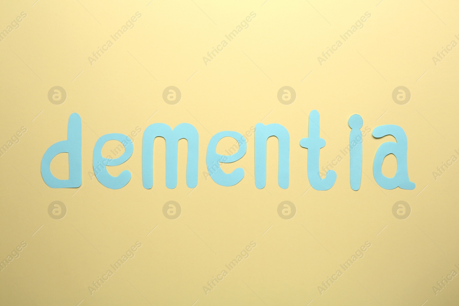 Photo of Word Dementia made of paper letters on beige background, flat lay