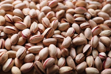 Many tasty pistachios as background, closeup view