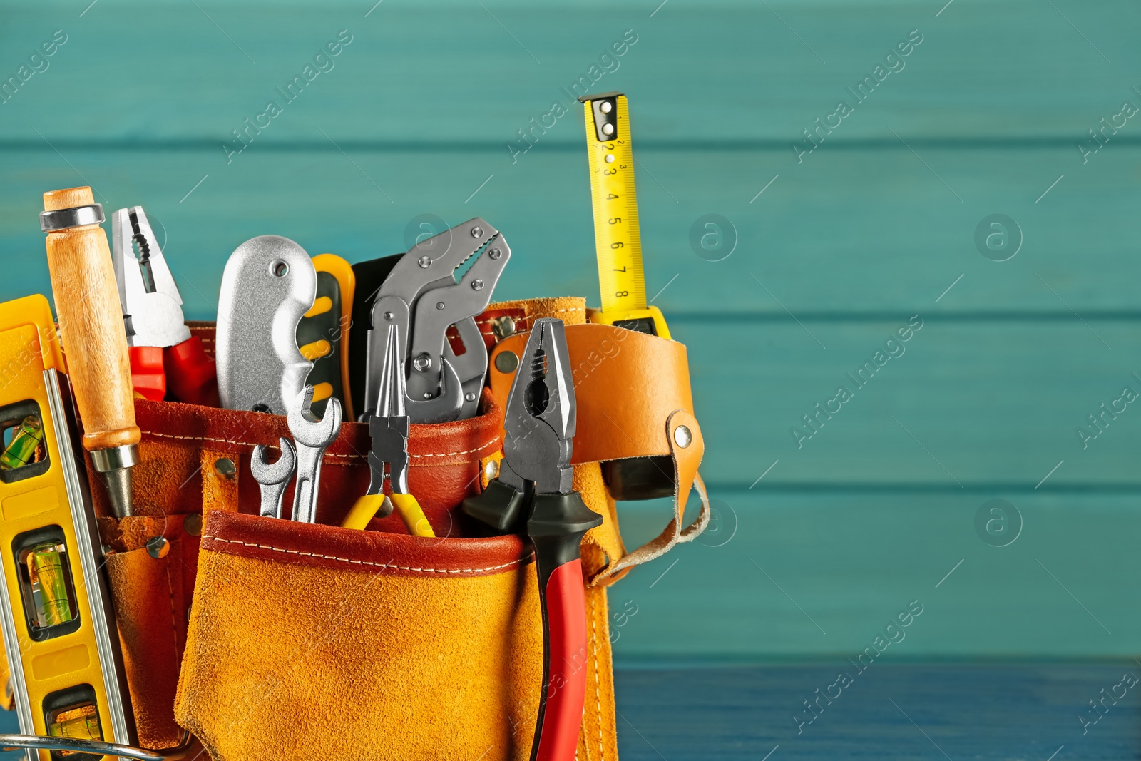 Photo of Belt with different tools on light blue wooden background. Space for text