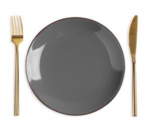 Empty plate, fork and knife on white background, top view