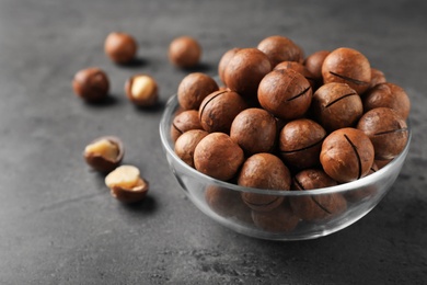 Photo of Bowl with organic Macadamia nuts and space for text on grey background