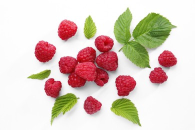 Photo of Tasty ripe raspberries and green leaves on white background, flat lay