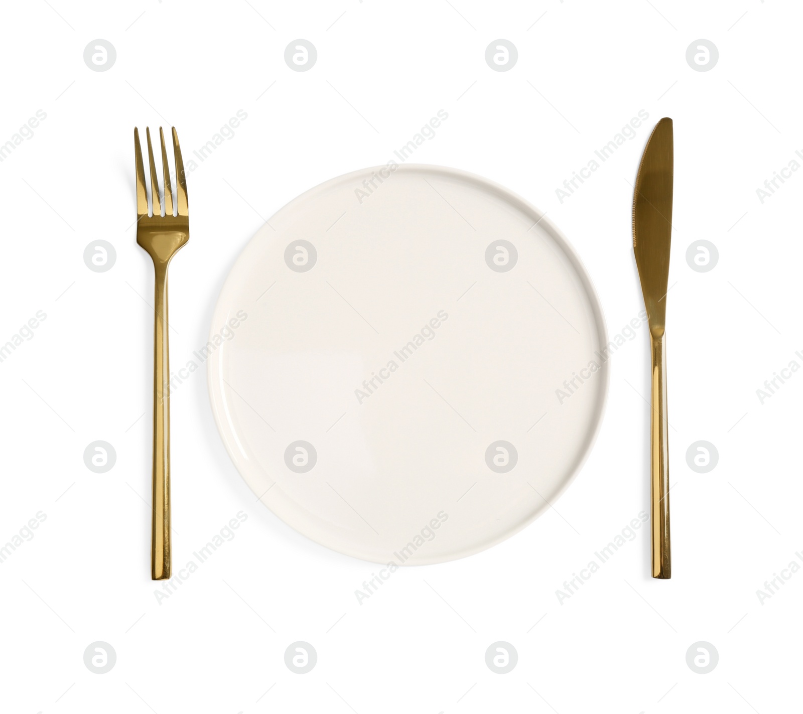 Photo of Clean plate and golden cutlery on white background, top view