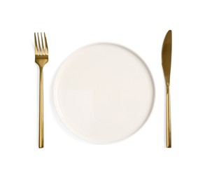 Photo of Clean plate and golden cutlery on white background, top view