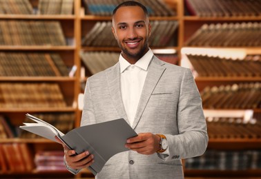 Image of Lawyer, consultant, business owner. Confident man with file folders smiling indoors