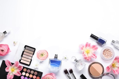 Photo of Flat lay composition with different makeup products and beautiful spring flowers on white background, space for text