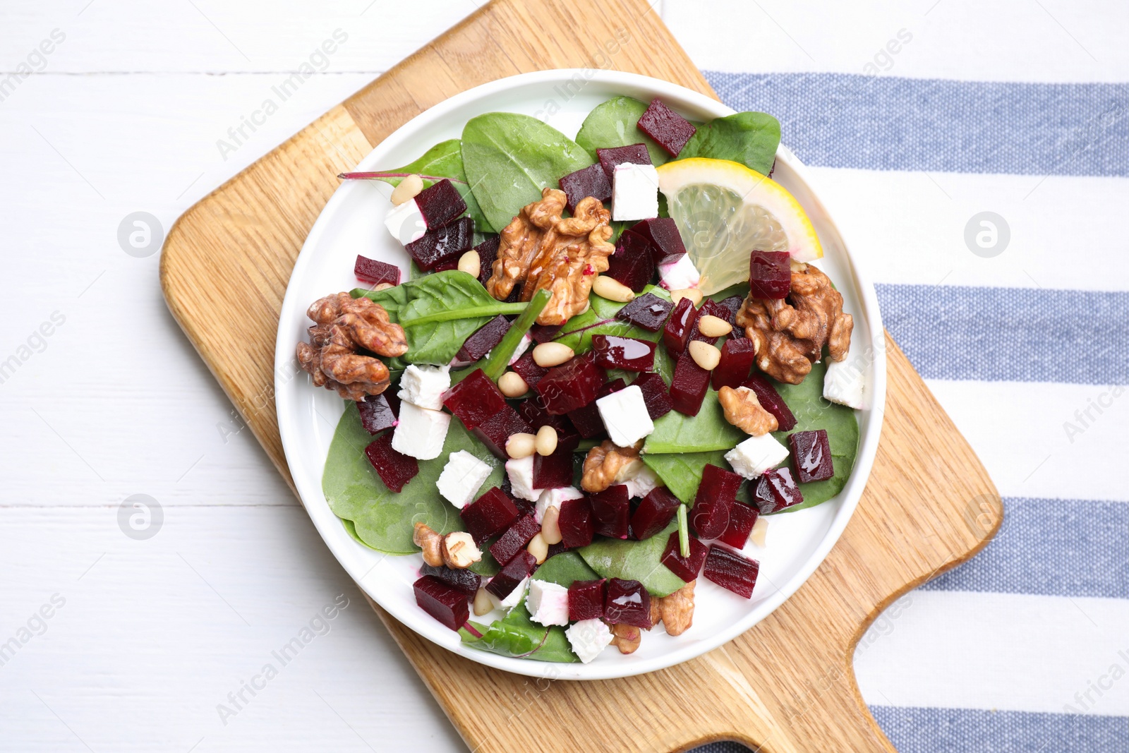Photo of Delicious beet salad served on white wooden table, top view